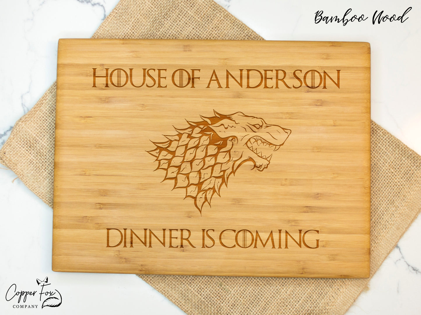 a wooden cutting board with a game of throne logo on it