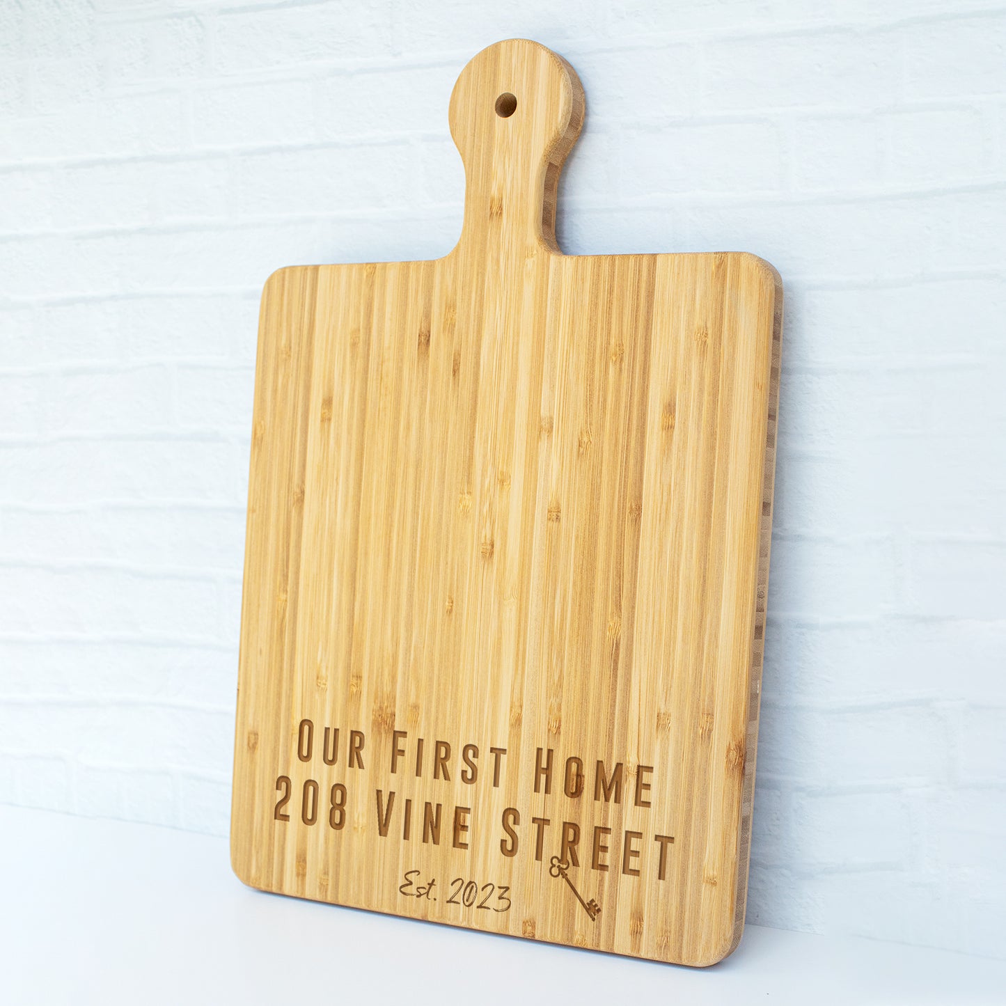 a cutting board with the words our first home wine street engraved on it