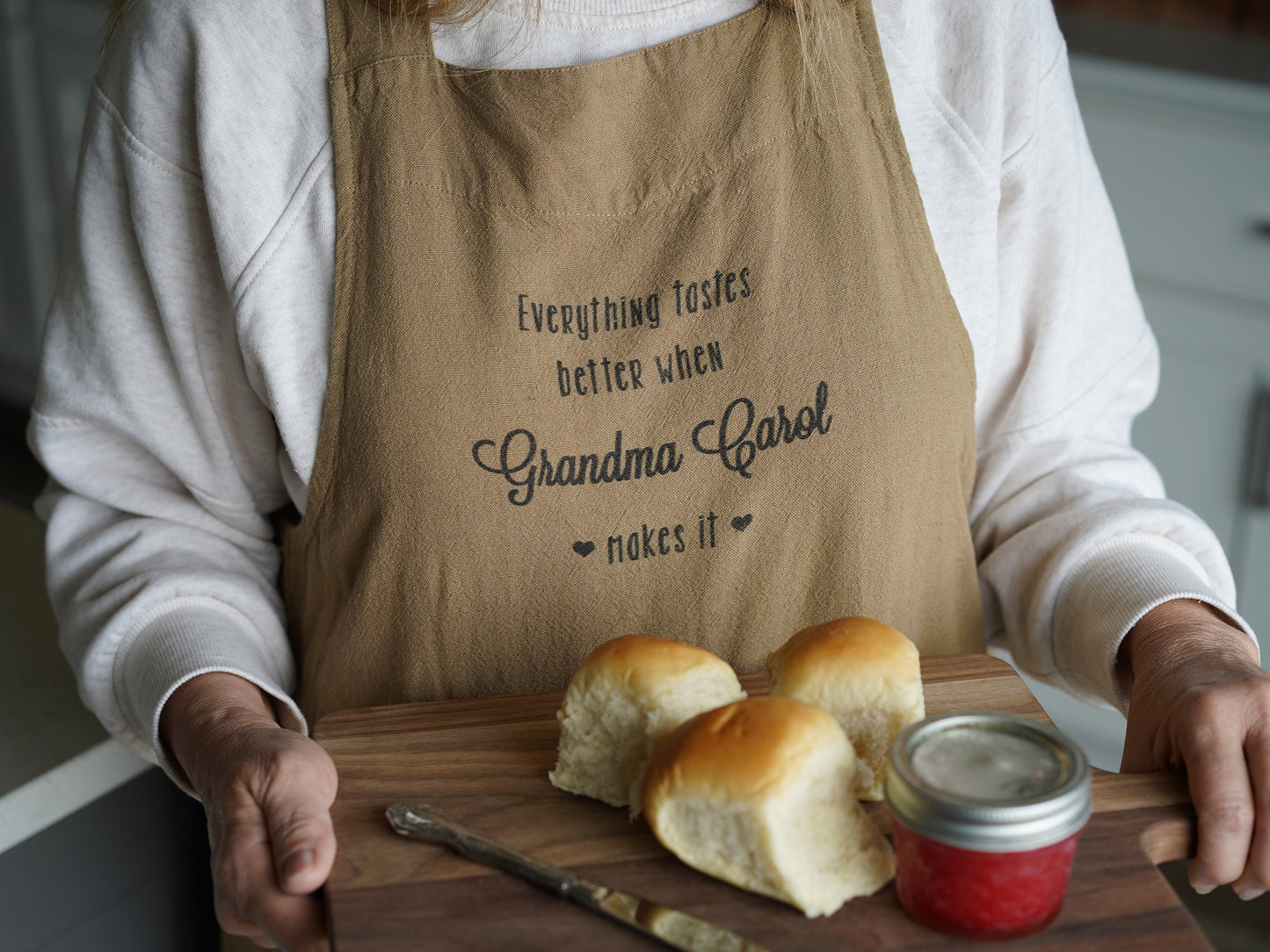 a woman holding a cutting board with rolls on it