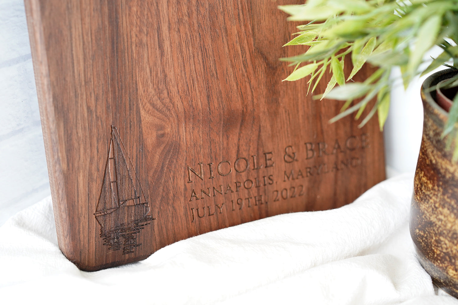 a wooden cutting board sitting next to a potted plant