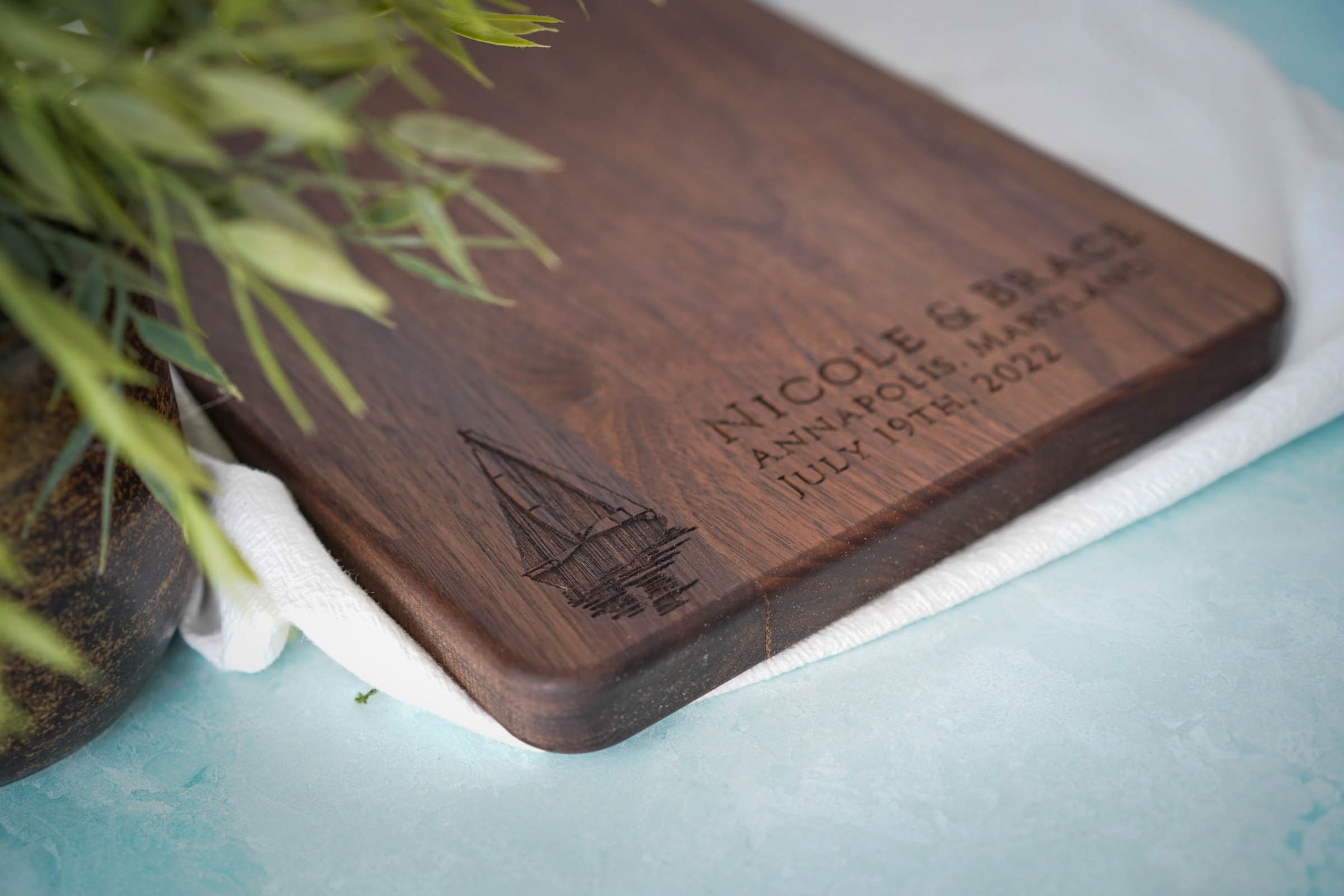 a wooden cutting board sitting next to a potted plant