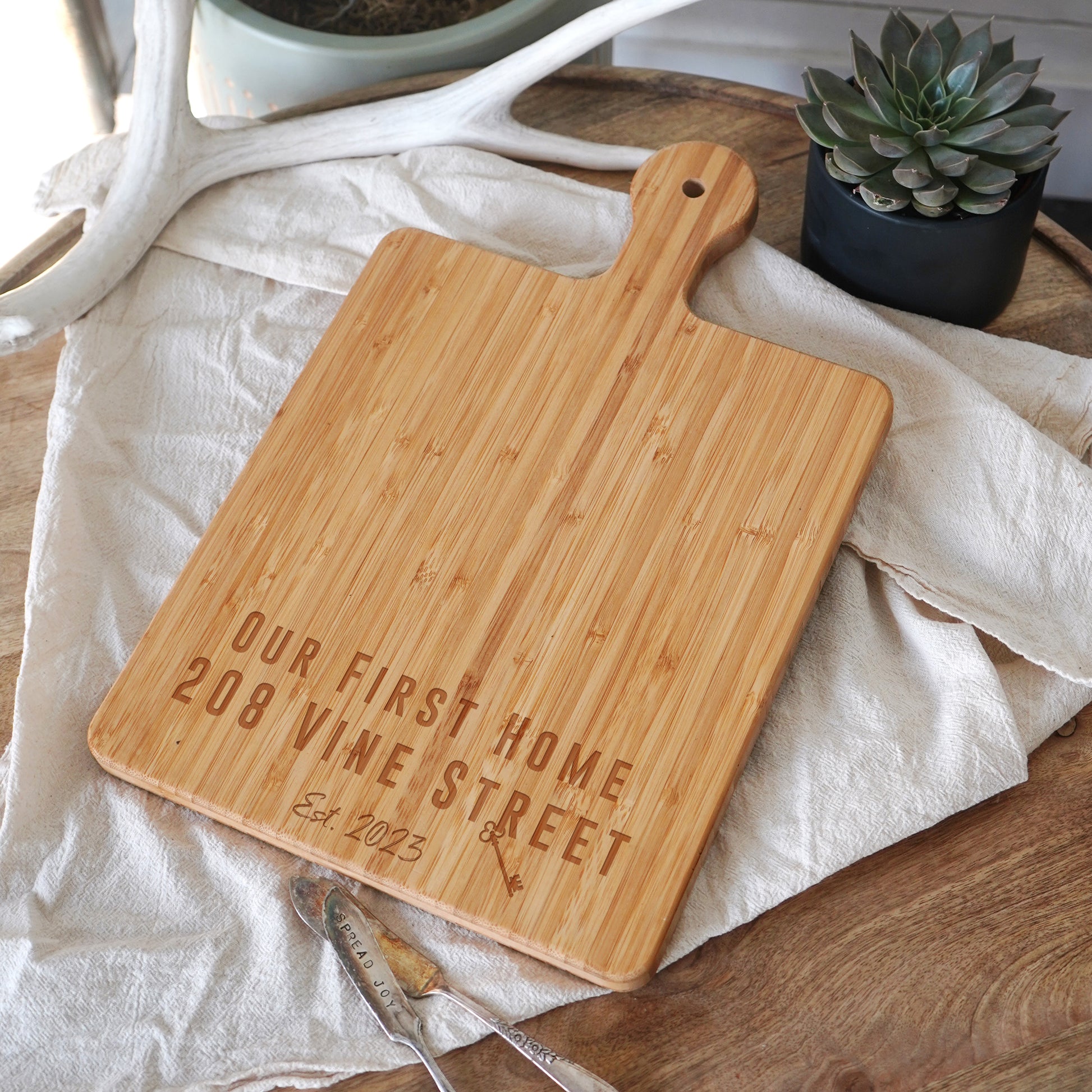 a cutting board that says our first home is wine street