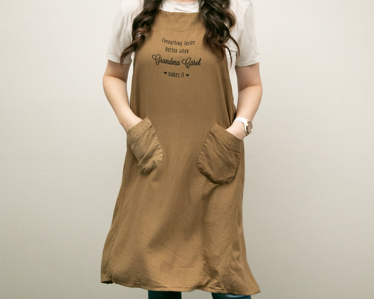 a woman wearing a brown dress with her hands in her pockets