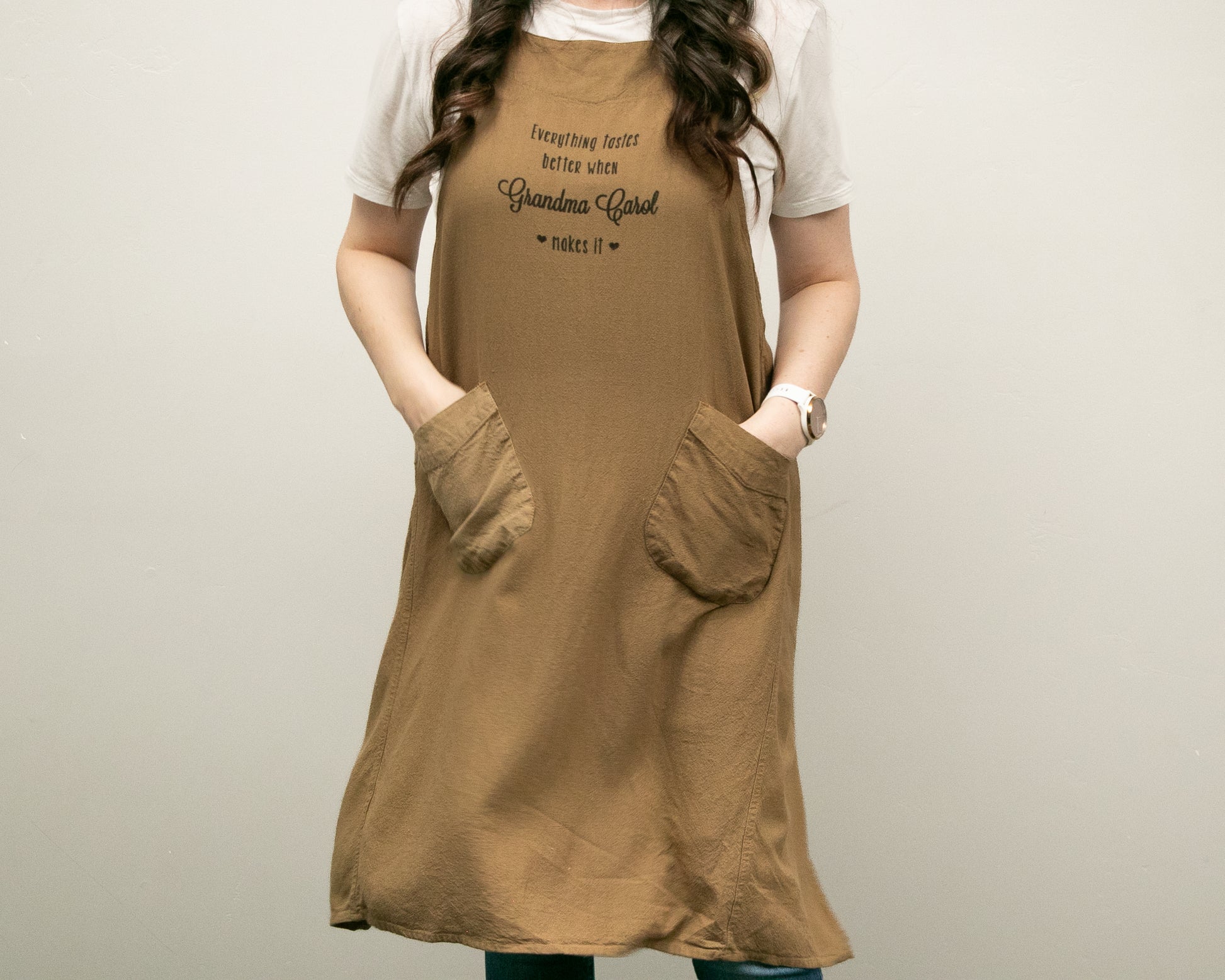 a woman wearing a brown dress with her hands in her pockets