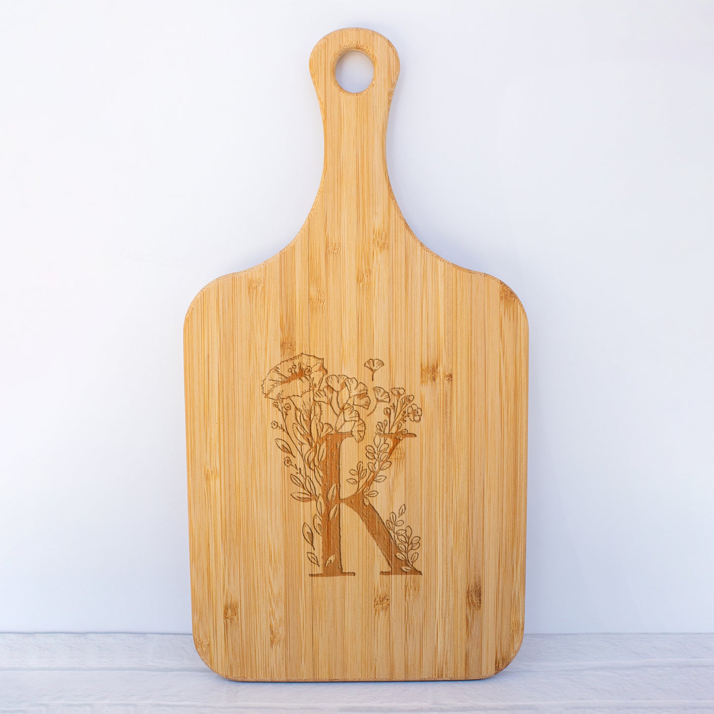 a cutting board with the letter k on it