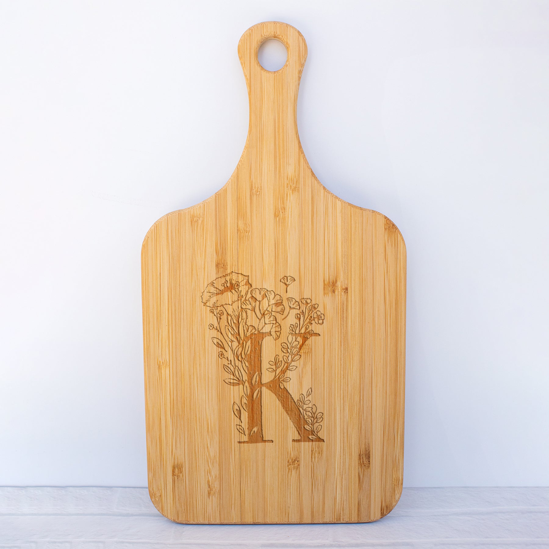a cutting board with the letter k on it