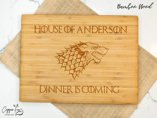 a wooden cutting board with a game of throne logo on it
