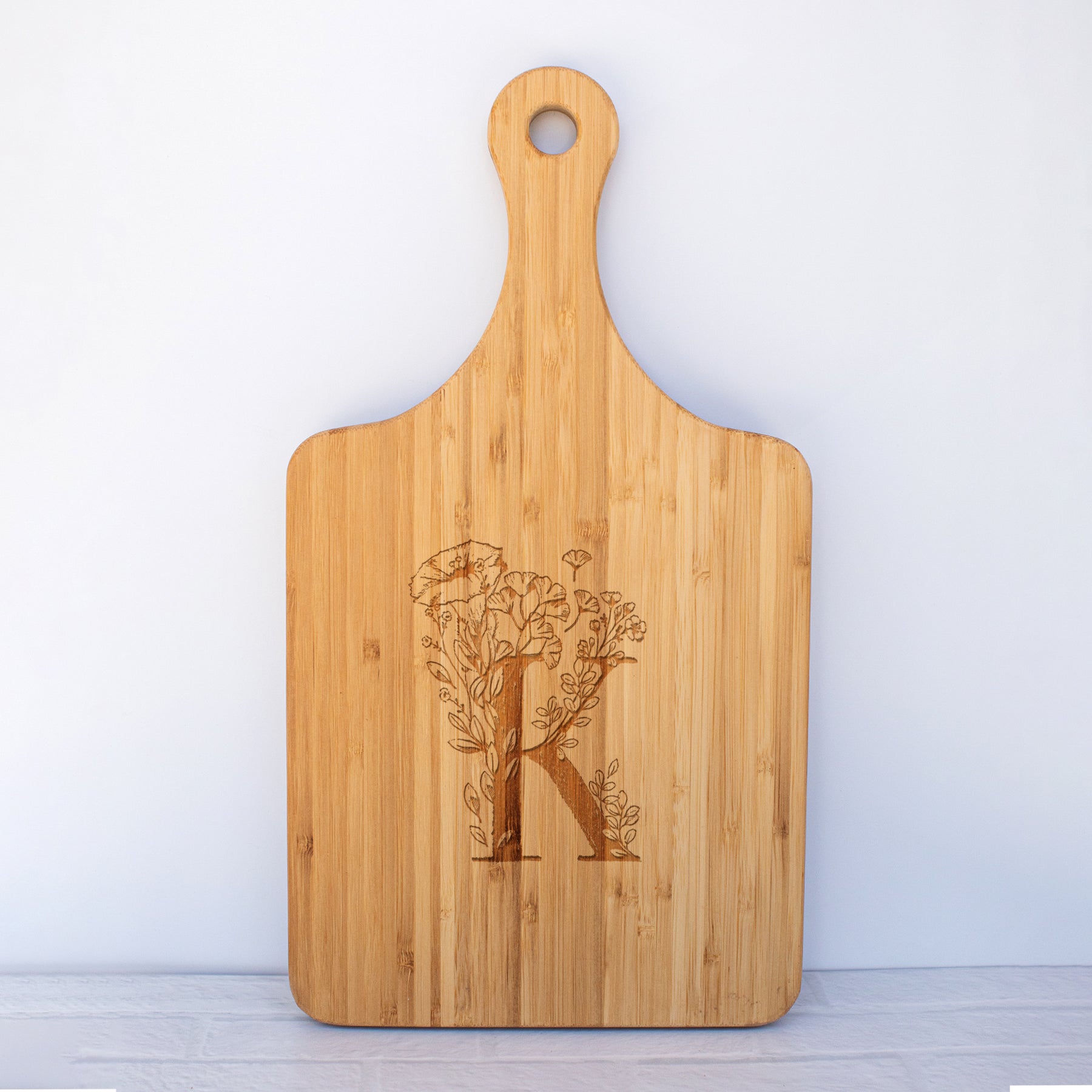 a cutting board with a monogrammed initial k on it