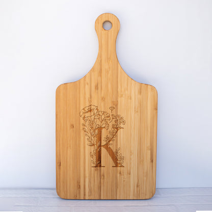a cutting board with a monogrammed initial k on it