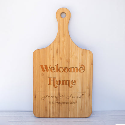 a wooden cutting board with the words welcome home on it
