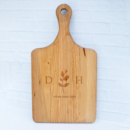 a wooden cutting board with a flower on it