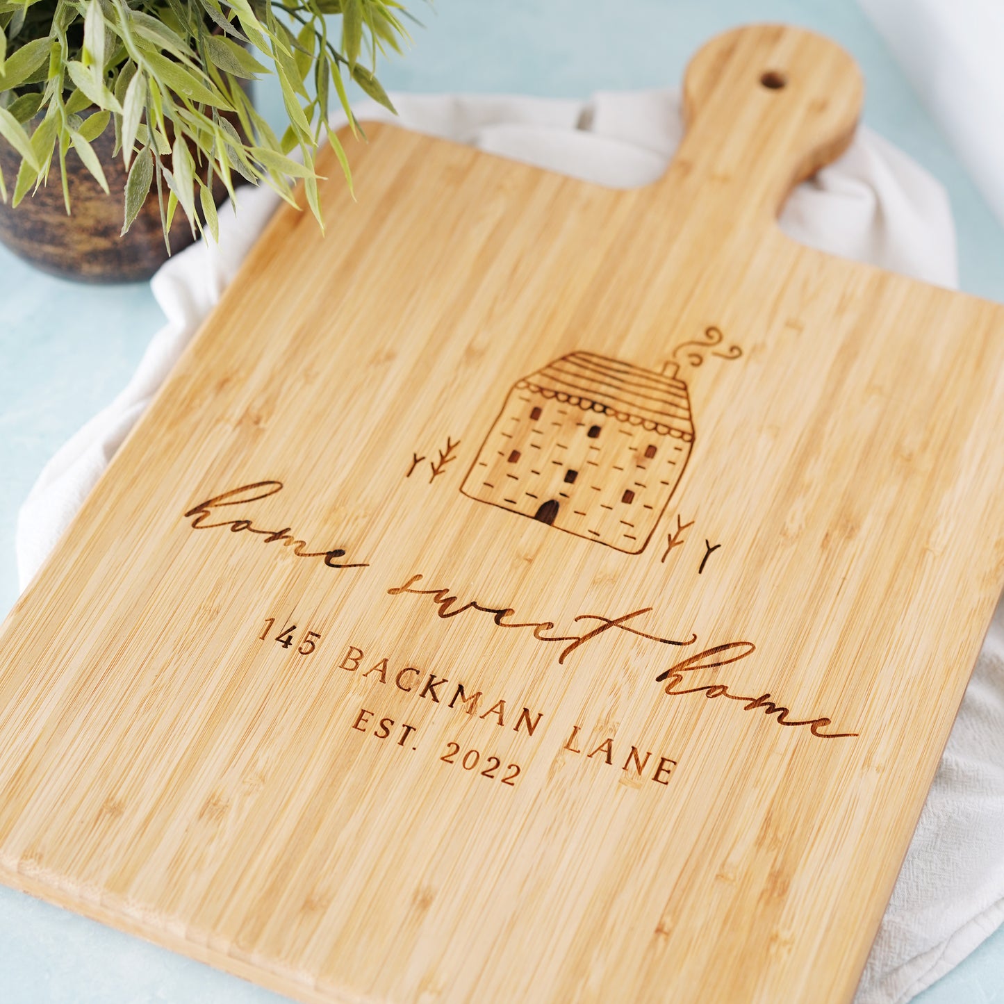 a wooden cutting board with a house on it