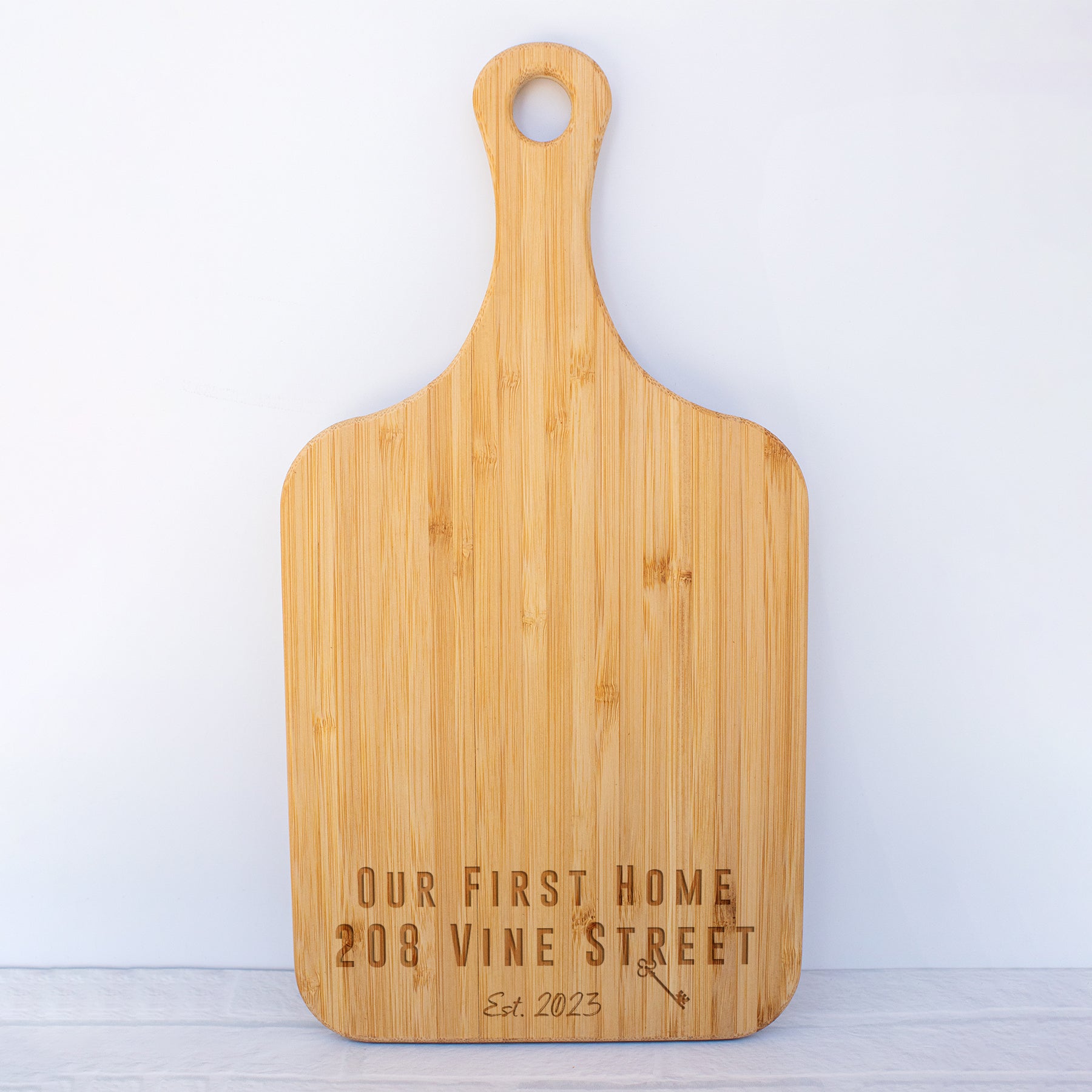 a wooden cutting board with the words our first home on it