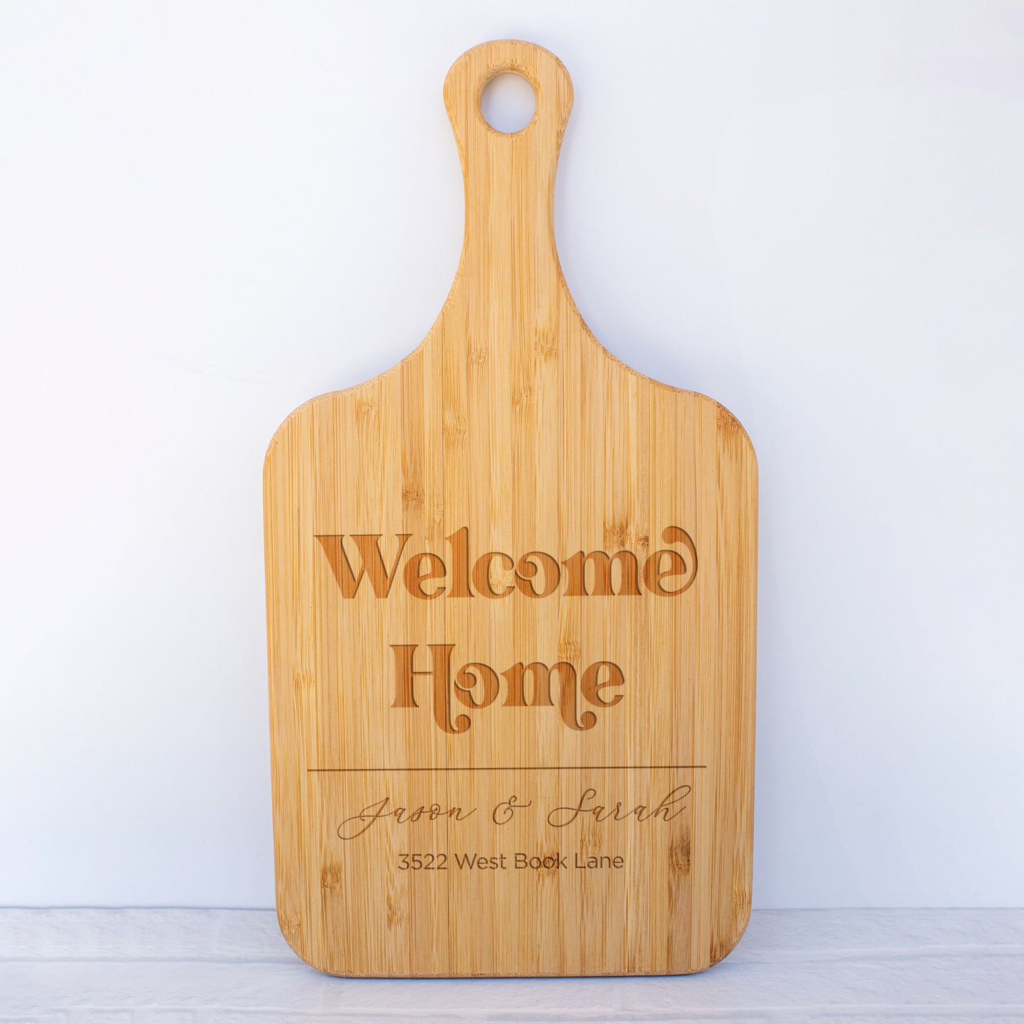 a cutting board with a welcome home sign on it