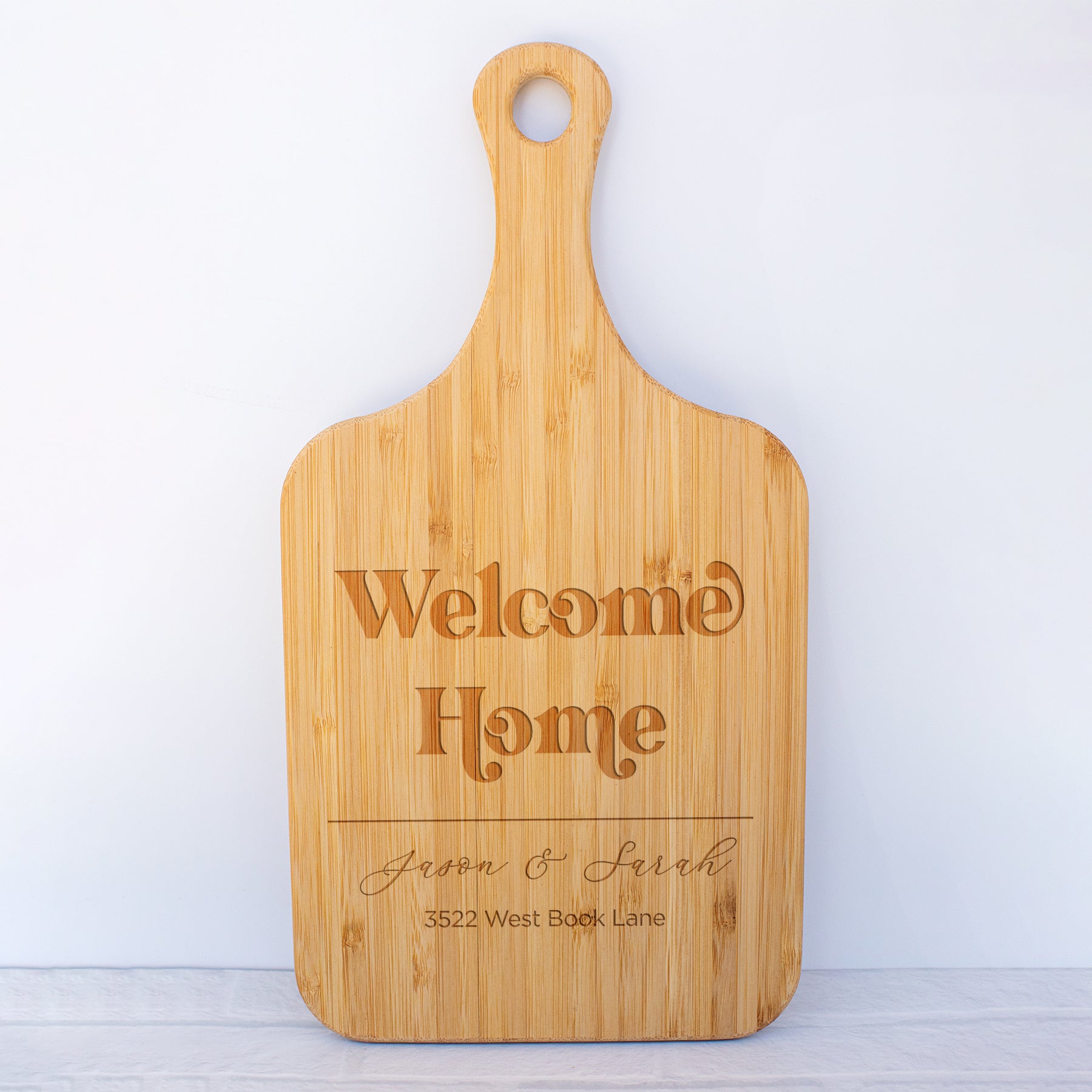 a cutting board with a welcome home sign on it