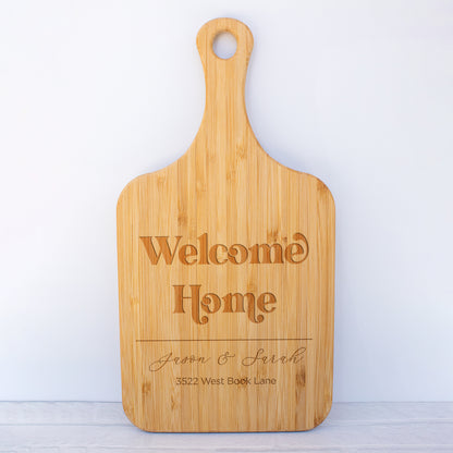 a cutting board with a welcome home sign on it