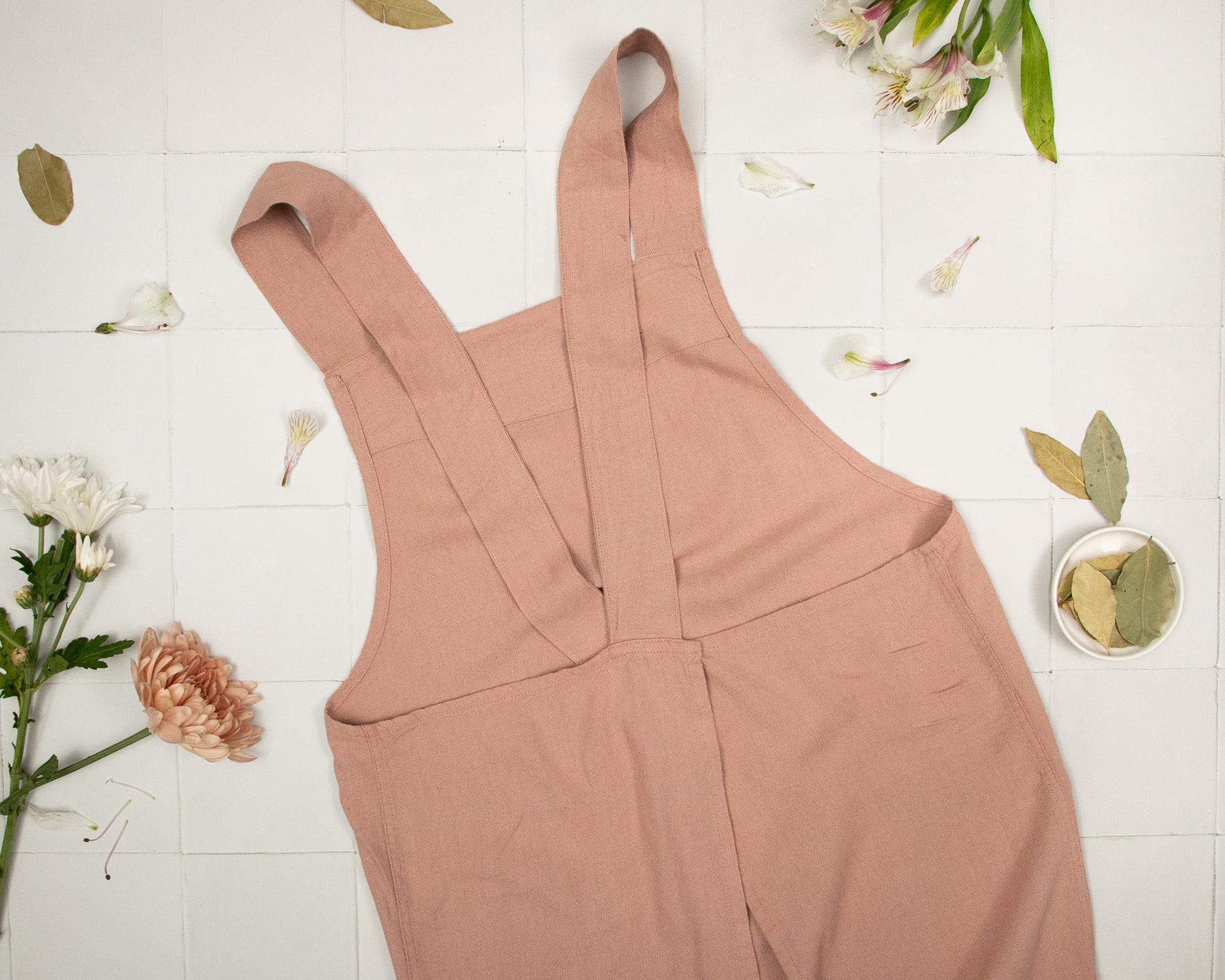 a pair of pink overalls sitting on top of a tiled floor