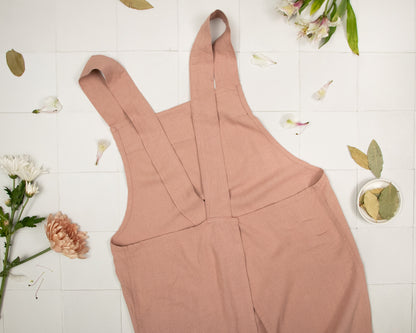 a pair of pink overalls sitting on top of a tiled floor