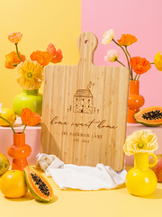 Home Sweet Home Cottage Cutting Board in a colorful floral setting