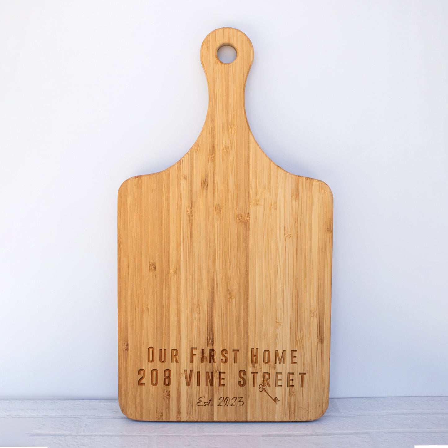 a wooden cutting board with a name on it