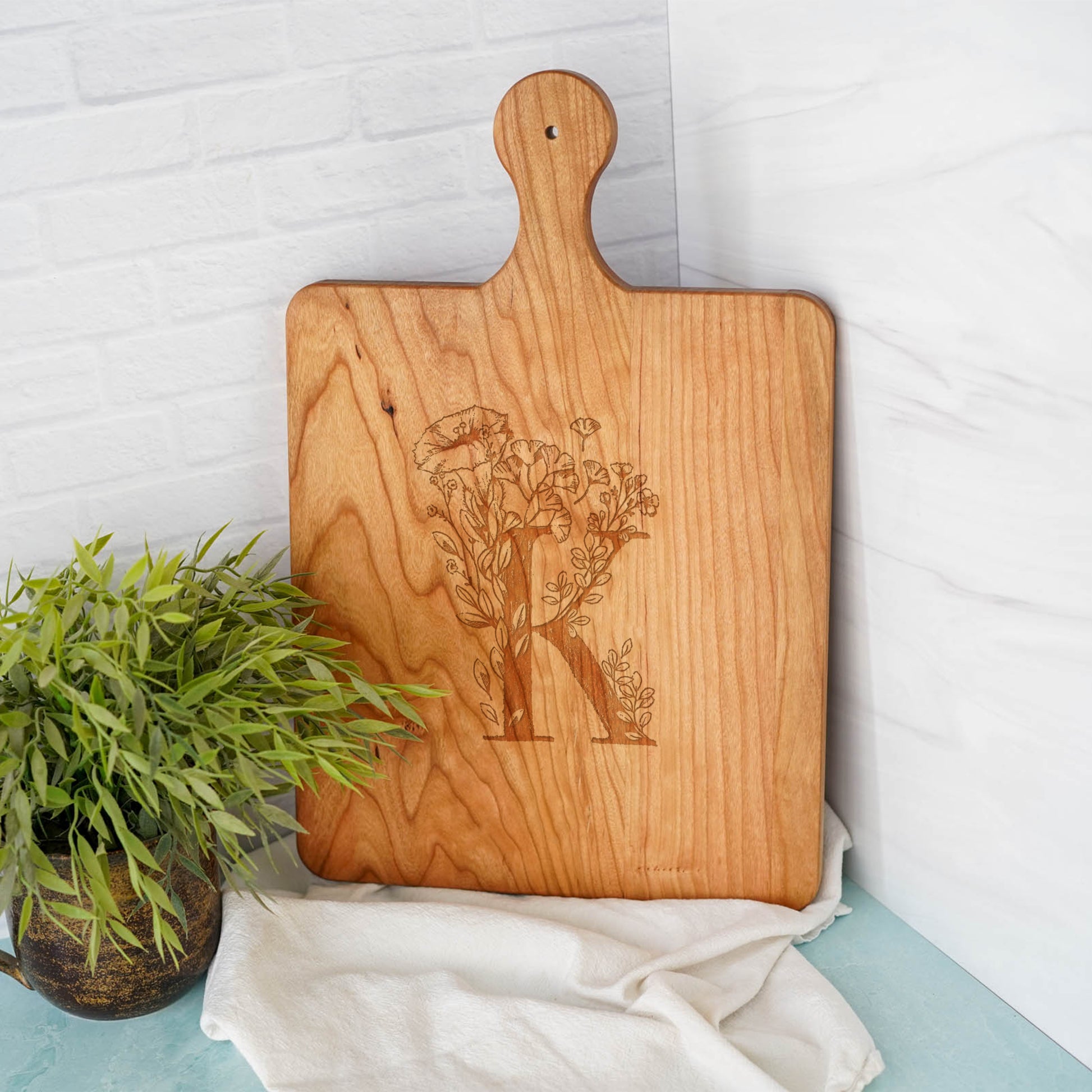 a cutting board sitting next to a potted plant