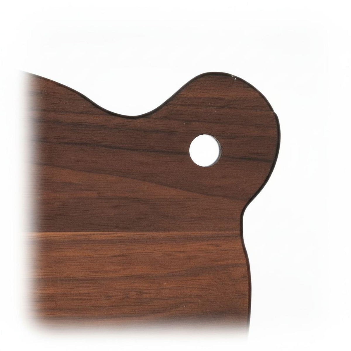 A close-up view of a wooden cutting board with a circular hole in the center.