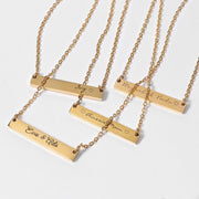 a collection of gold-colored metal necklaces with personalized engraved names on them.