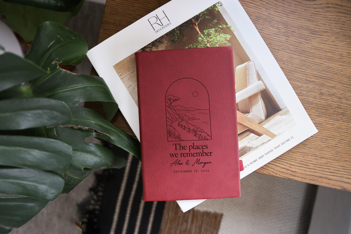 Places journal mockup with a deep rose-colored cover on an interiors catalog beside green leaves; coastal artwork with Alex & Morgan and September 19, 2026.
