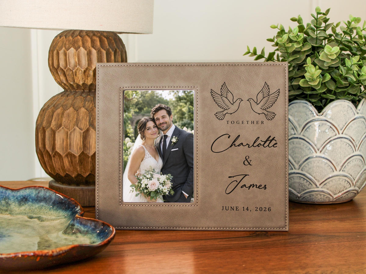 Edited mockup of the Together frame beside a lamp and plant, with an illustrative wedding portrait at left and paired doves, Charlotte & James, and June 14, 2026 at right.