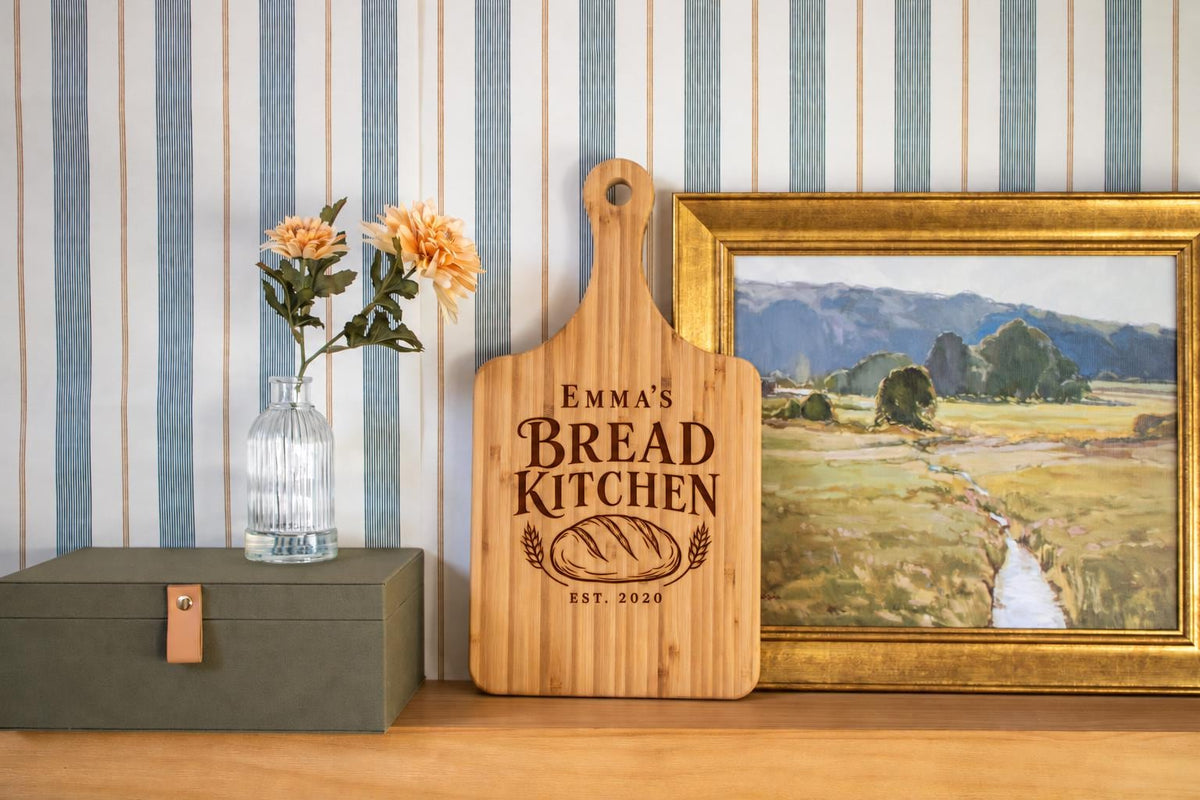 Generated engraving mockup of Emma’s Bread Kitchen with loaf, wheat and EST. 2020 on a bamboo cheese board.