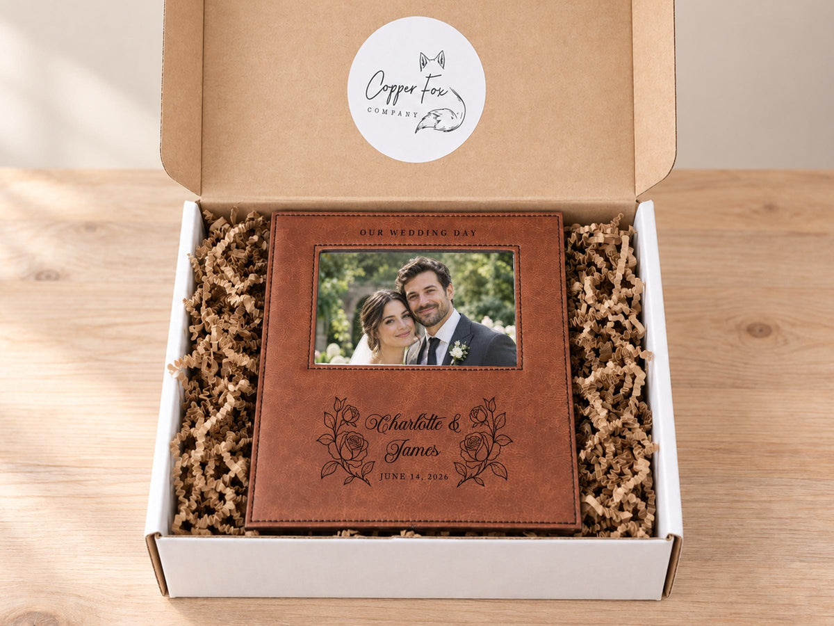 Wedding Roses frame mockup with a sample wedding photo, OUR WEDDING DAY, roses, Charlotte & James and June 14, 2026, in an open gift box with crinkle paper.