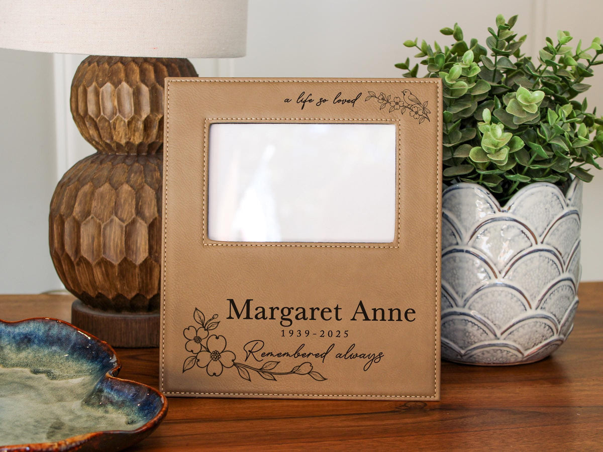 Edited a life so loved memorial frame mockup with songbird and floral engraving, Margaret Anne and 1939-2025; empty photo opening for Gift Options: None.