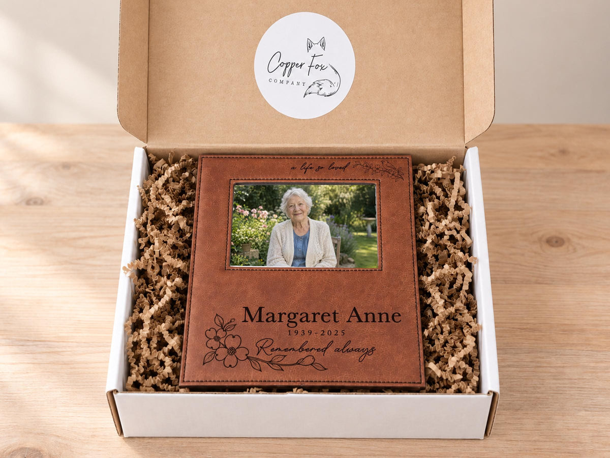 Edited a life so loved memorial frame mockup in an open gift box with crinkle paper, personalized Margaret Anne, 1939-2025, with an illustrative portrait.