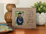 Grad Cap engraved frame reading Class of 2027, Olivia Bennett, Westbridge High School, with an illustrative graduation portrait. Edited mockup with sample personalization.