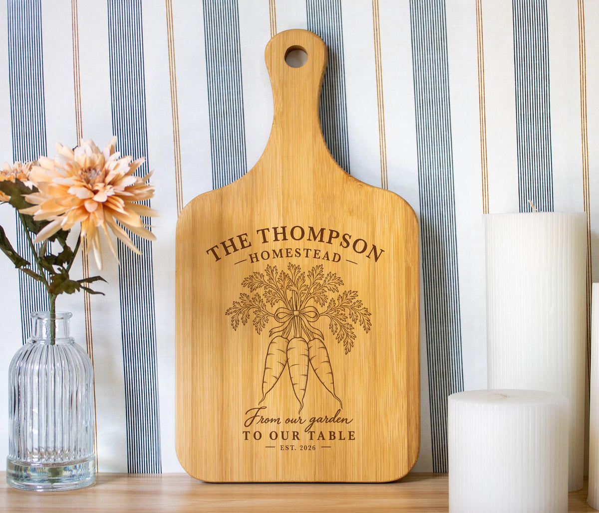 Edited Homestead Carrots mockup on a light bamboo paddle board with carrot engraving and sample Thompson Homestead personalization.