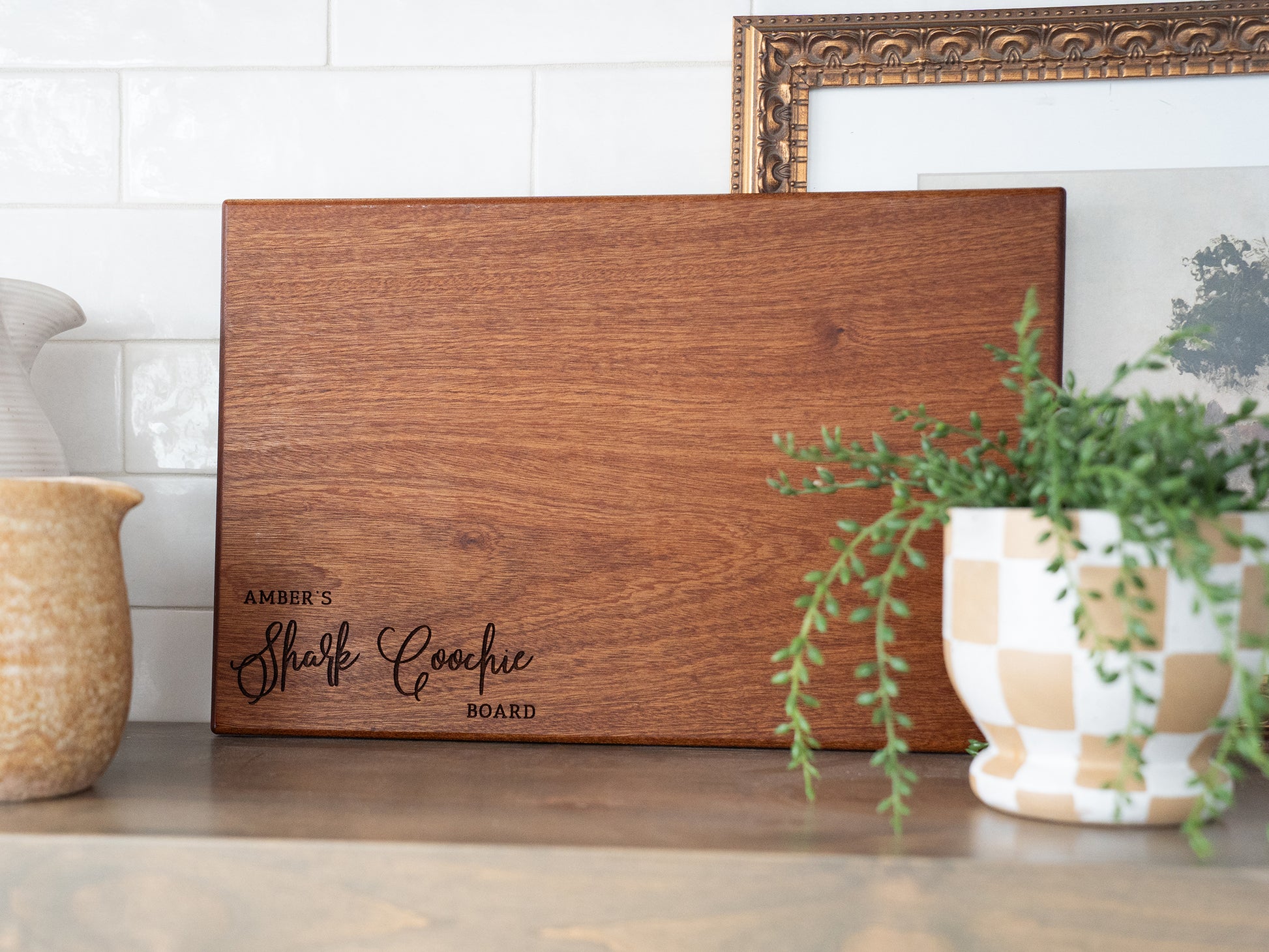 a wooden sign sitting on top of a table next to a potted plant