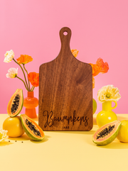 Modern Cursive Family Name Cutting Board in a colorful floral setting